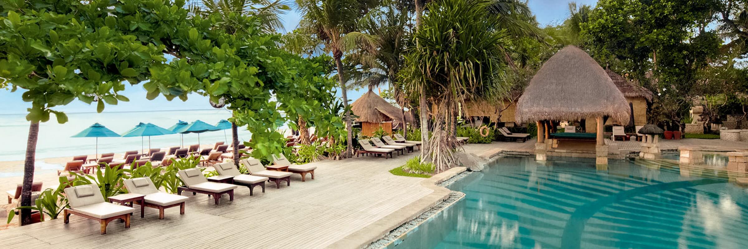 Sonnenliegen am Pool unweit des Strandes des Novotel Bali Benoa Resorts