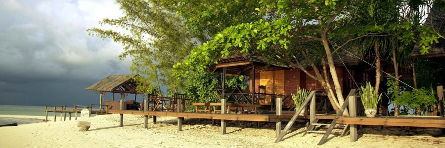 Panoramaansicht der Chalets des Lankayan Island Dive Resort, die sich entlang des herrlichen Sandstrandes verteilen