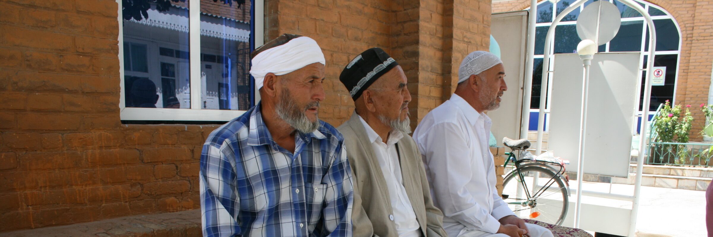 Menschen in Usbekistan vor der Moschee