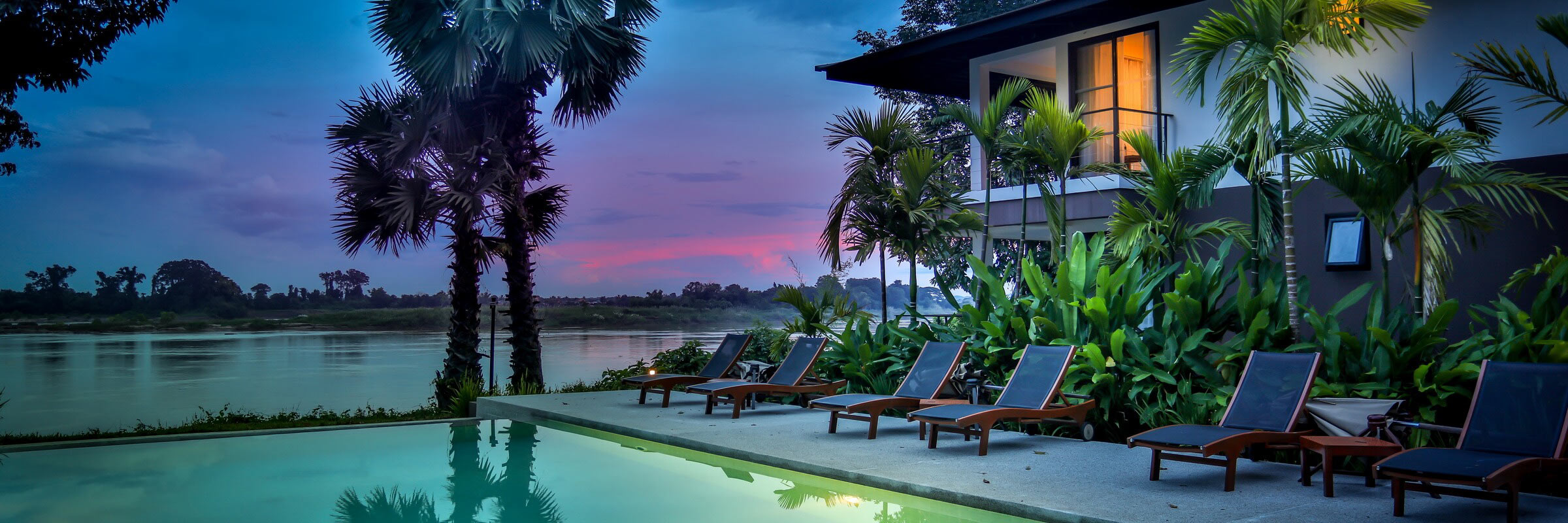 Infinity-Pool mit Sonnenterasse bei Sonnenuntergang im Herzen des River Resort Champasak