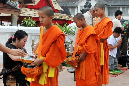 Novizen und Mönche beim Tak Bat in Luang Prabang
