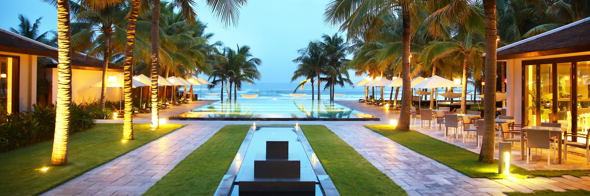 Der einladende Pool mit Sonnenterasse mit direktem Panorama Blick auf das Meer im Fusion Maia Danang Resort