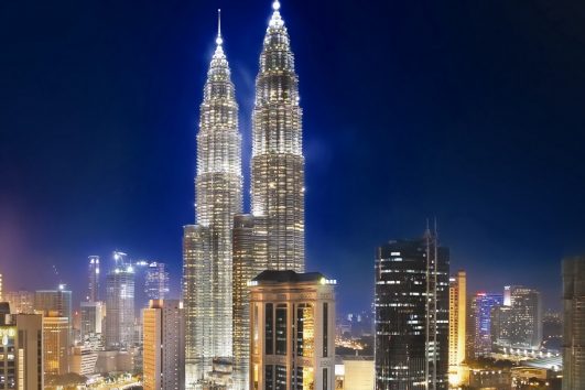 Kuala Lumpurs bei Nacht hell erleuchtete Skyline ist atemberaubender Anblick, der zu den Höhepunkten einer Malaysia-Rundreise zählt.