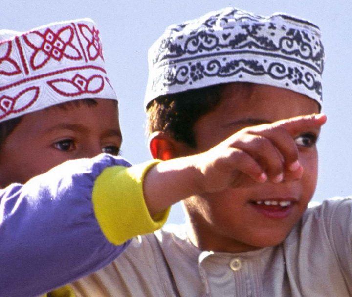 Zwei Jungen in traditioneller omanischer Kleidung, dem Kumma und Dishdasha.