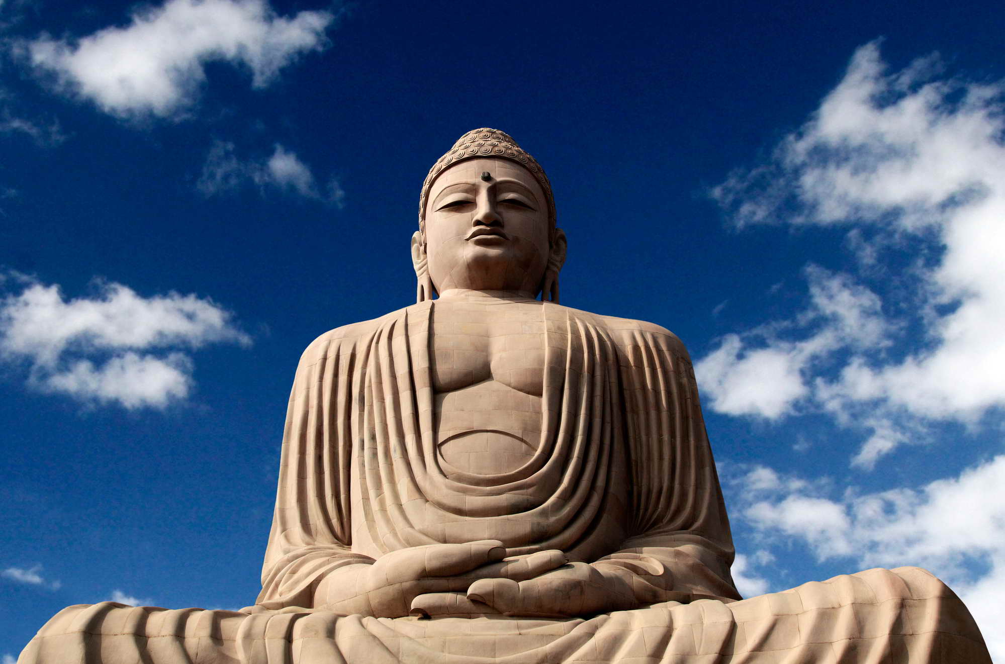 Bodhgaya in Nordindien zählt seit 2002 zum UNESCO Weltkulturerbe und ist ein buddhistisches Pilgerzentrum mit vielen Tempeln und Klöstern. Die meditierende Buddhastatue wurde 1989 vom Dalai Lama enthüllt.