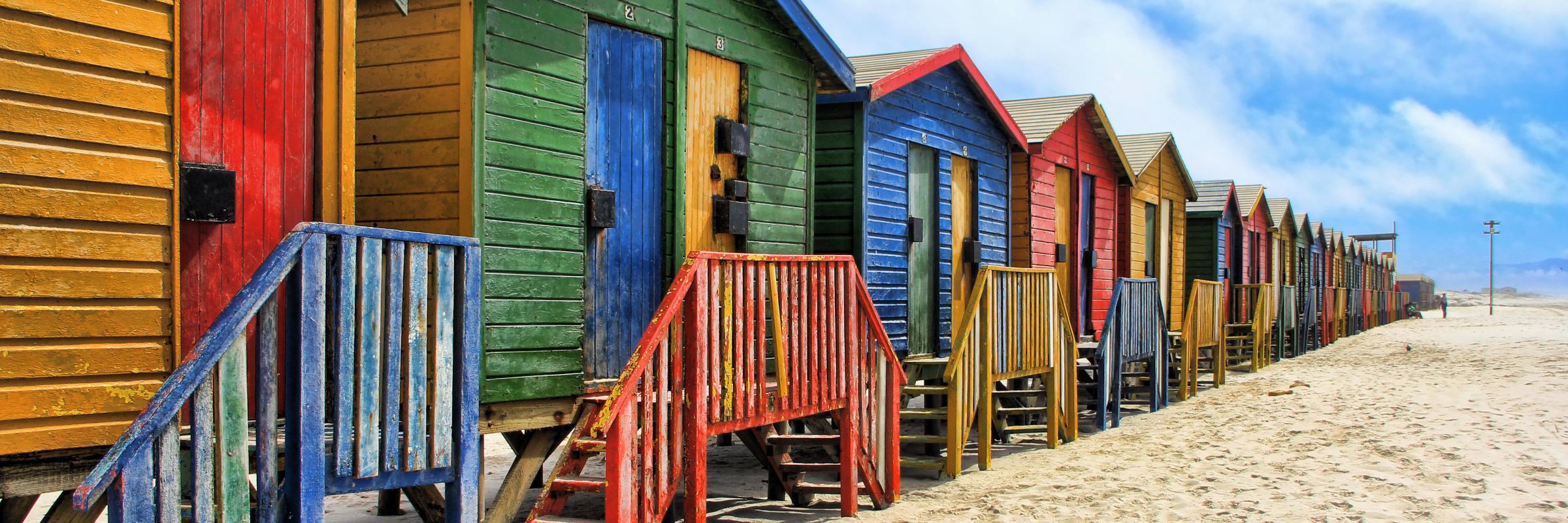 Die vielen bunten Strandhäuschen sind das Wahrzeichen von Muizenberg nahe Kapstadt in Südafrika.