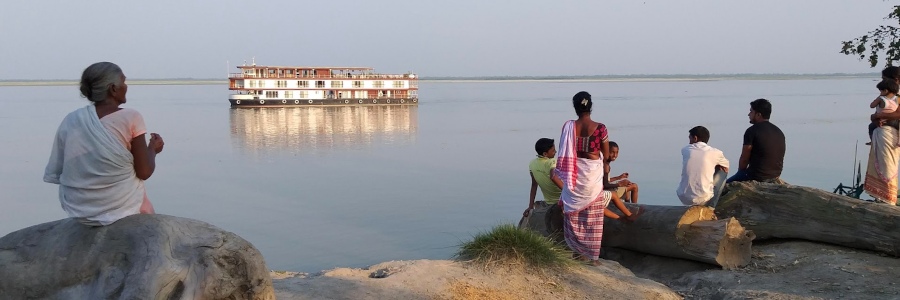Einheimische betrachten am Ufer des Brahmaputra die vorbeifahrende Charaidew II.