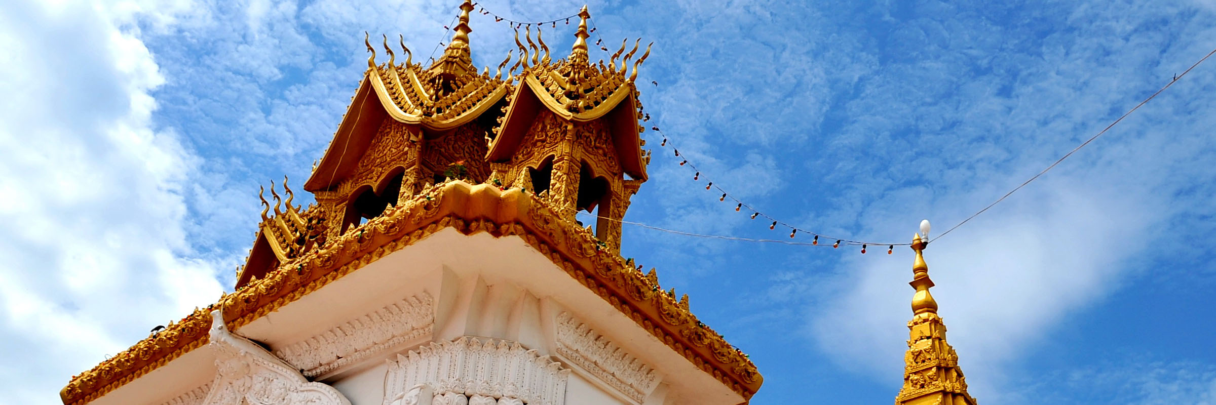 Durch das reichhaltig verzierte Eingangstor gelangt man auf das Gelände des Stupas Pha That Luang in Vientiane.
