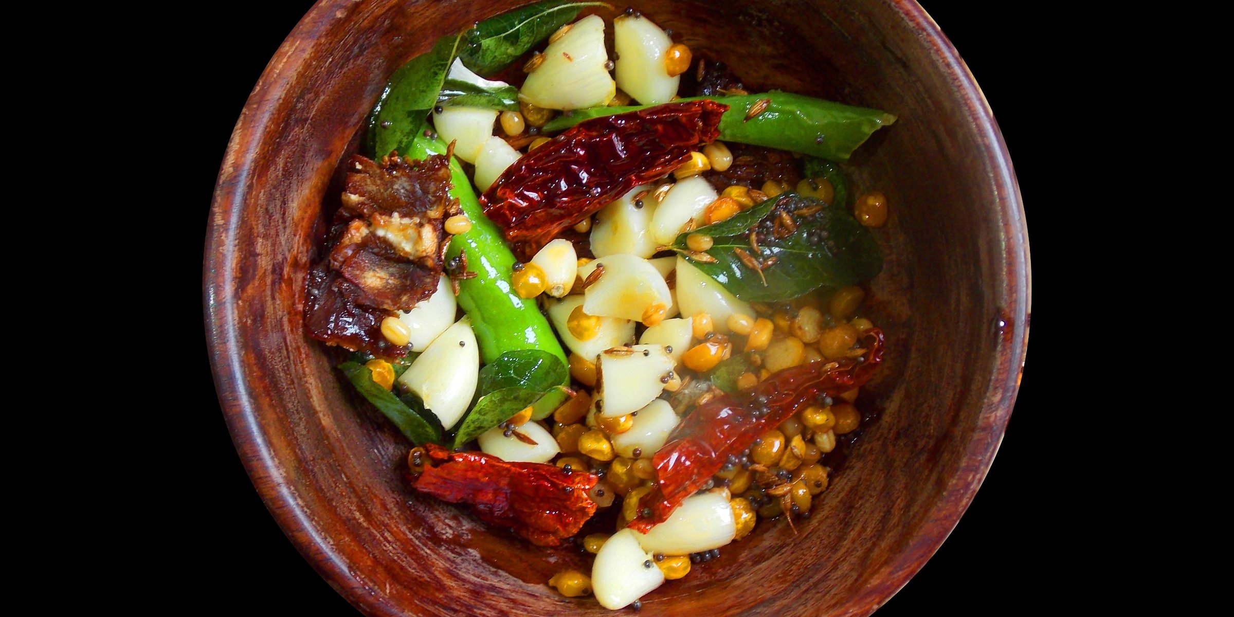 Chana Dal, ein indisches Gericht aus Kichererbsen, Knoblauchzehen und getrockneten roten und grünen Chilis