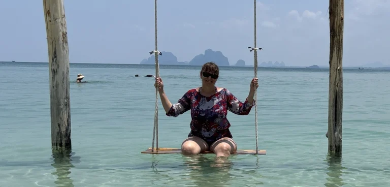 Team-Insights: Ramona auf Koh Mook Reiseexpertin Ramona auf einer Wasserschaukel am Traumstrand auf Koh Mook während ihrer Thailand-Reise.