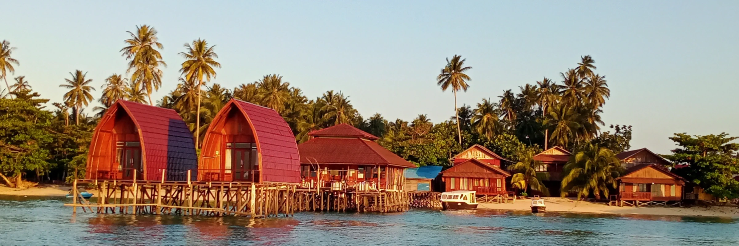 Gemütliche Holz-Bungalows der Derawan Dive Lodge auf Stelzen direkt am Wasser der Insel Derawan, Kalimantan – ein zentraler Stopp der Wildlife- und Tauch-Rundreise.