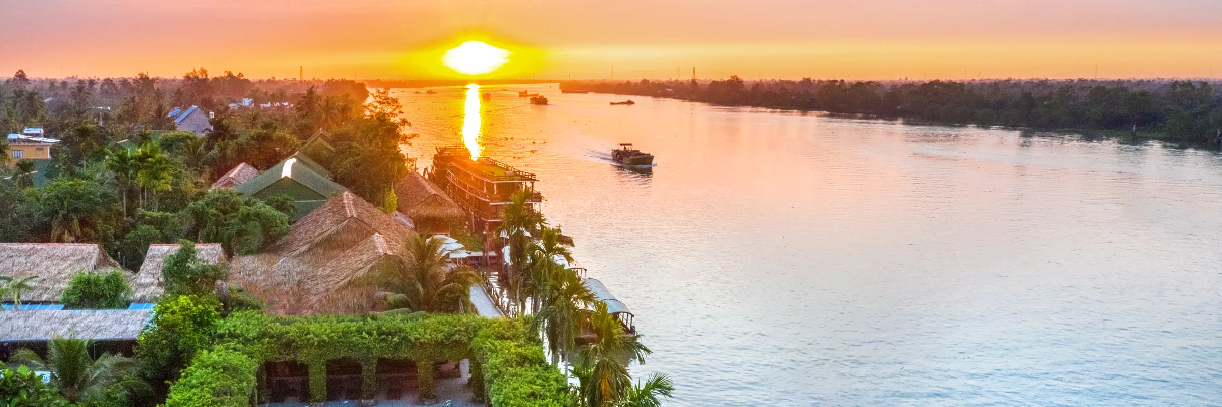 Panorama-Luftaufnahme der Mekong Lodge am Flussufer im Mekong-Delta bei Sonnenuntergang