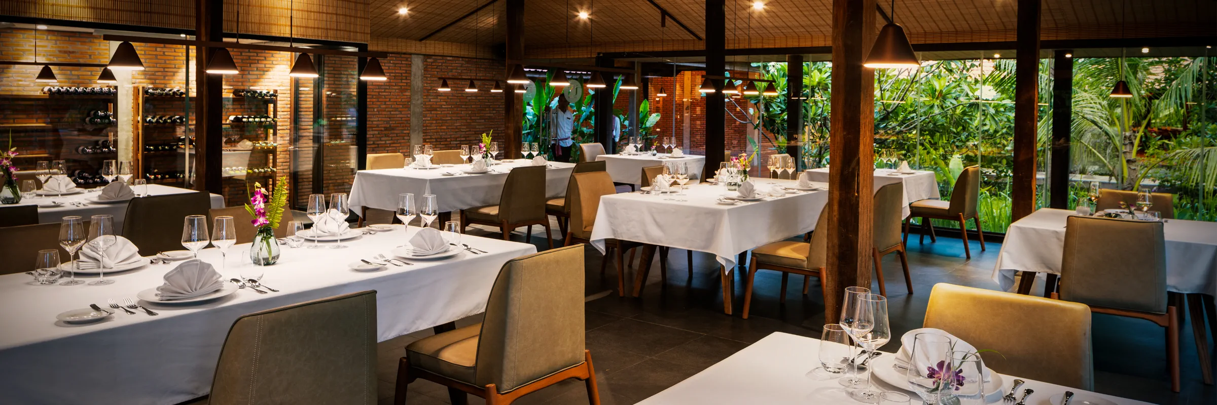 Festlich eingedeckte Tische im Innenbereich des Restaurant UN im Farmhouse Resort & Spa.