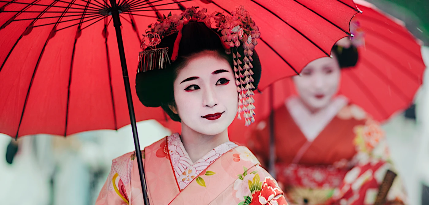 Junge Maiko in historischem Gewand in den Straßen des japanischen Kyoto