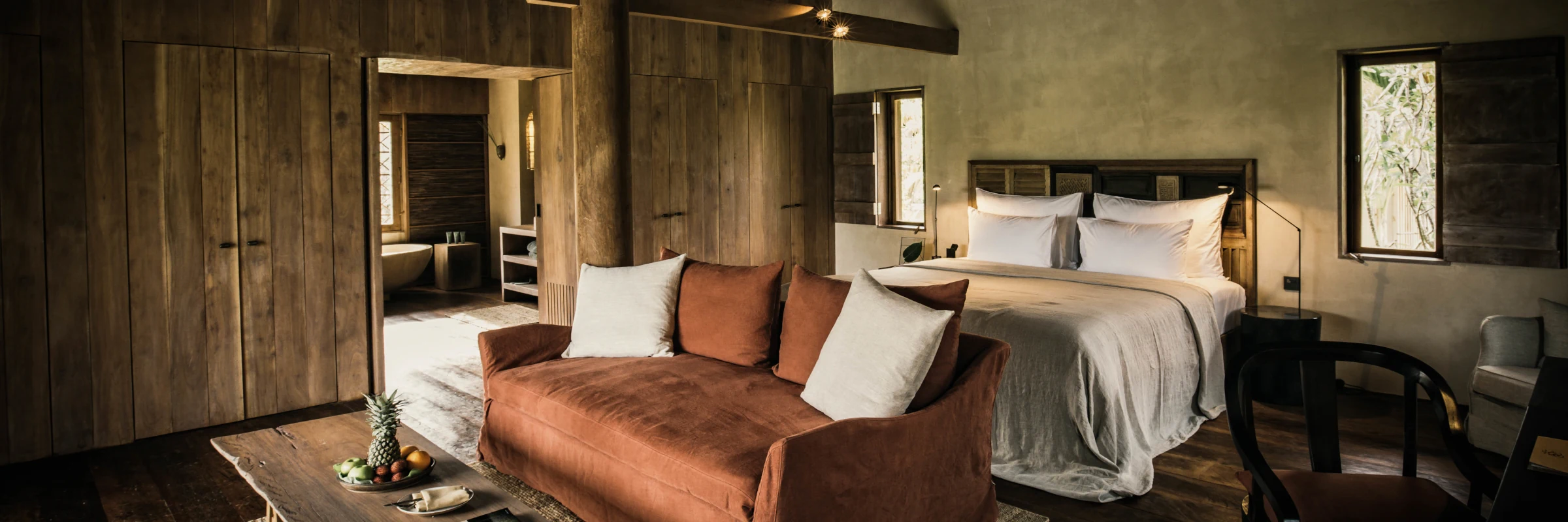 Luxuriöser Schlaf- und Wohnbereich einer Holzvilla im Resort Zannier Phum Baitang mit Blick auf das Badezimmer.